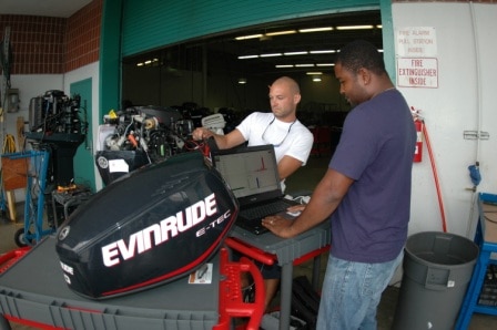students working on evinrude boat motor