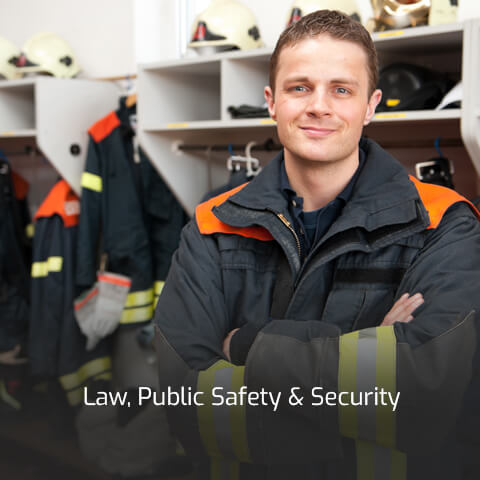 A young public safety professional stands proud in his firefighter uniform.