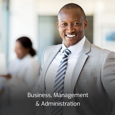 A business man in a gray suit and blue-striped tie smiles and stands tall.